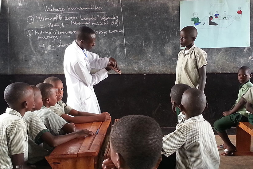 A teacher at GS Gishari using sign language to instruct learners.  (By Diane Mushimiyimana)