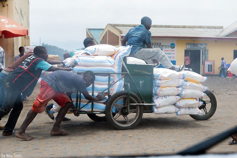 Members of a traders' cooperative of people living with disabilities push a cart of goods from Gisenyi town to cross into Goma in DR Congo last week. Faustin Niyigena.