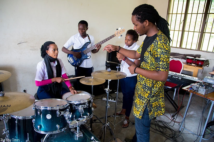 Alumni Igor Mabano instructs singer Ruth Kanoheri Christmas on how to drum. She is in level four at the Rubavu-based Nyundo School of Art and Music. The director of its three-year-....