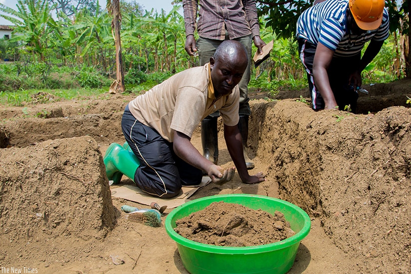 Ntagwabira and one of the two professional Rwandan archaeologists scrub soil from the former king's palace for sample analysis. (All photos by Faustin Niyigena)