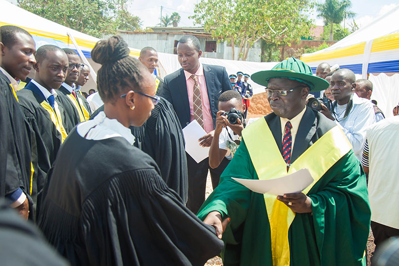 Prof Peter Opio, KIM-University vice chancellor, gives graduates their degree certificates during on Friday. (Nadege Imbabazi)