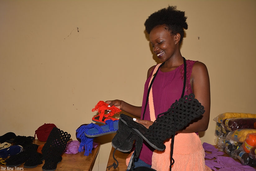 Ahirwe admires some of the products made by Posh Creative Ltd. (Photos by Frederic Byumvuhore)