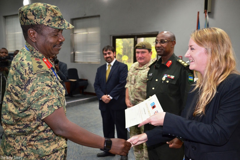 Col J K Mukasa from UPDF receives his certificate from Ms Gemma Thompson from UK High Commission to Rwanda as RPA Director Col Jill Rutaremara looks on. (Courtesy)