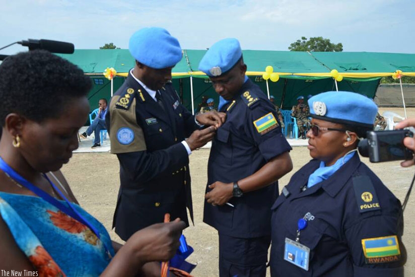 Commissioner of Police Bruce Munyambo, who represented the Special Representative of the UN Secretary-General, decorates Rwandan peacekeepers serving as Formed Police Unit under th....