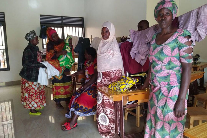Aileen Uwayezu, right, poses for a picture inside her group's tailoring shop. She and others are determined to make it big in their business. / James Karuhanga