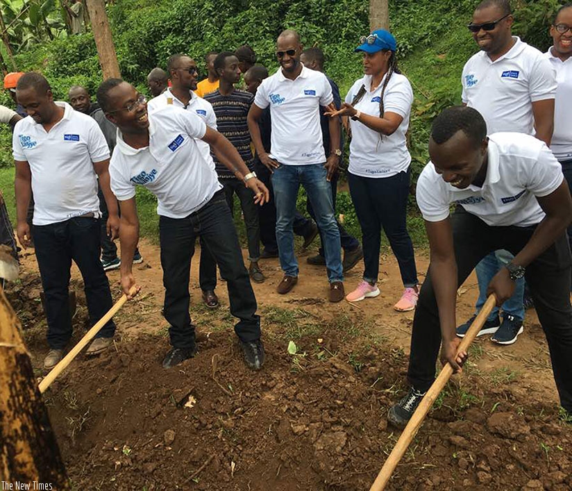 Amoateng (second left) joins Tigo staff during the event in Burera District.  (Courtesy)