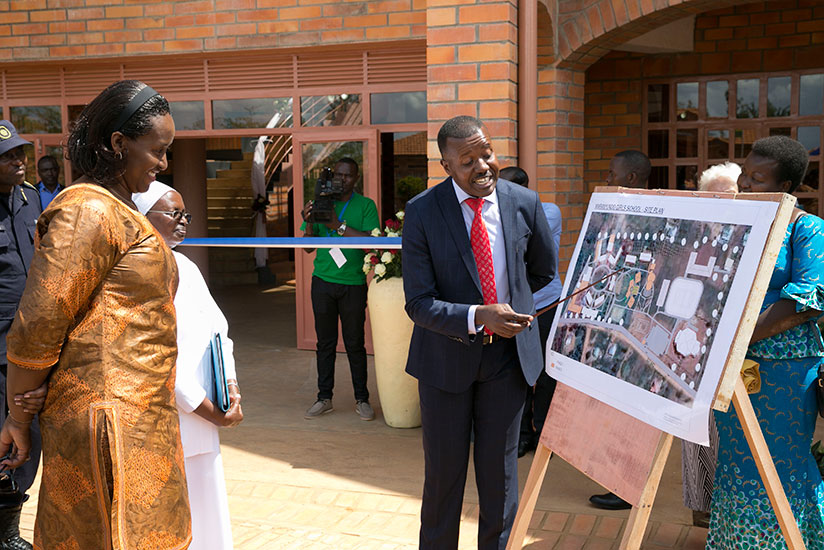 First Lady Jeannette Kagame observing the blueprint of Maranyundo Girls School's new educational facilities during the the first A Level graduation ceremony at the school yesterday....