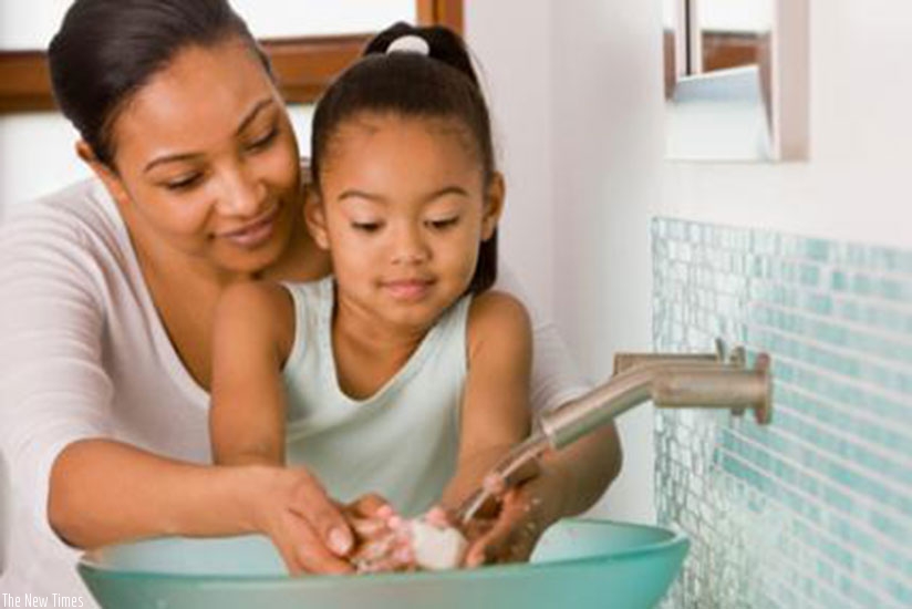 A mother helps her baby to wash its hands. Proper hygiene practices are key in keeping children safe from diseases. / Net photo.