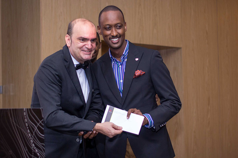 One of the clients receives his prize from Alonso (left). / Peterson Tumwebaze
