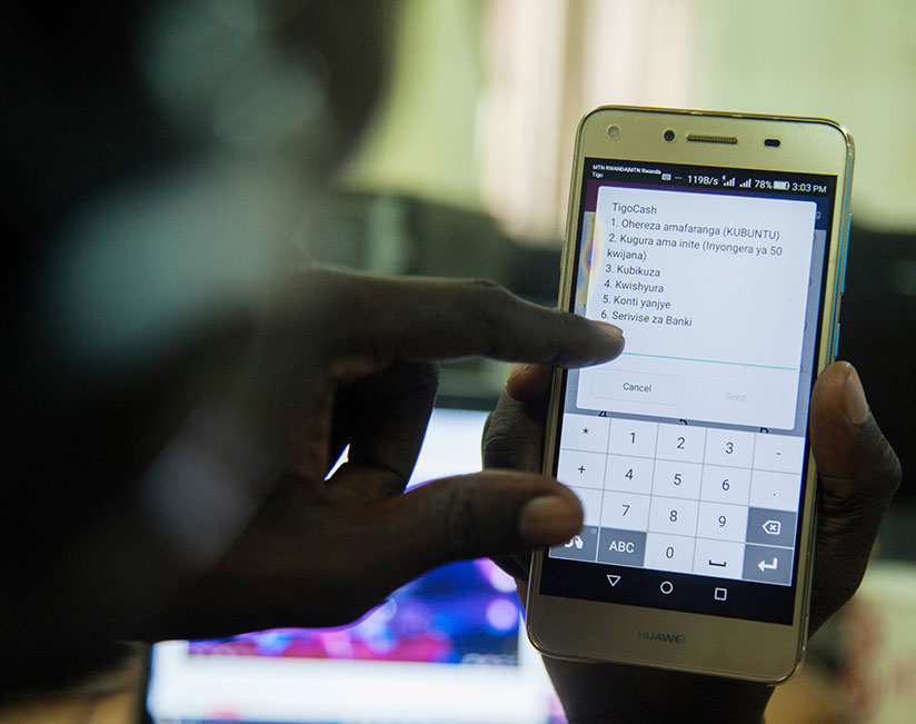 A Tigo customer makes a transaction. Iterambere Fund managers are looking to introduce mobile money payments. / File