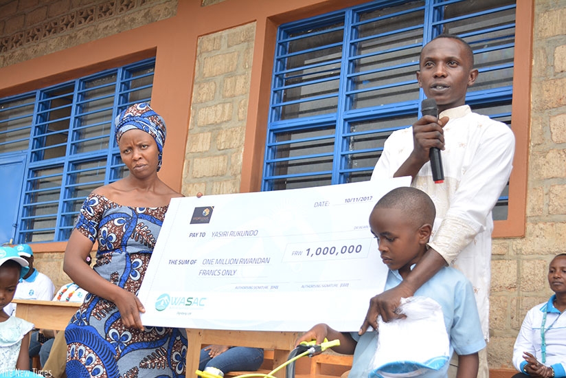 Rukundou2019s parents were given a cheque of Rwf1 million to enable them to support their childu2019s studies. / Frederic Byumvuhore