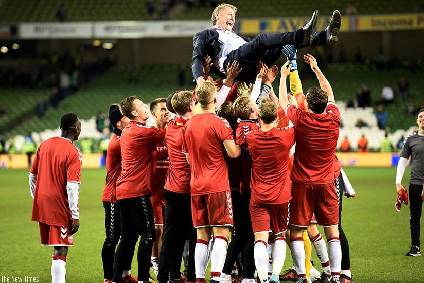 Denmark's players lift coach Age Hareide into the air after they dismantled Ireland with a clinical display on Tuesday night. (Net photo)