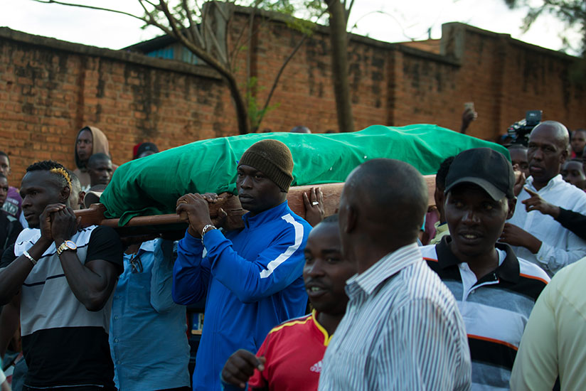Rayon Sports players, including Ismailla Diarra (left) and Tidiane Kone (right), carry the body of the Blues' former assistant coach Hamadi Katauti Ndikumana from his home in Nyaka....