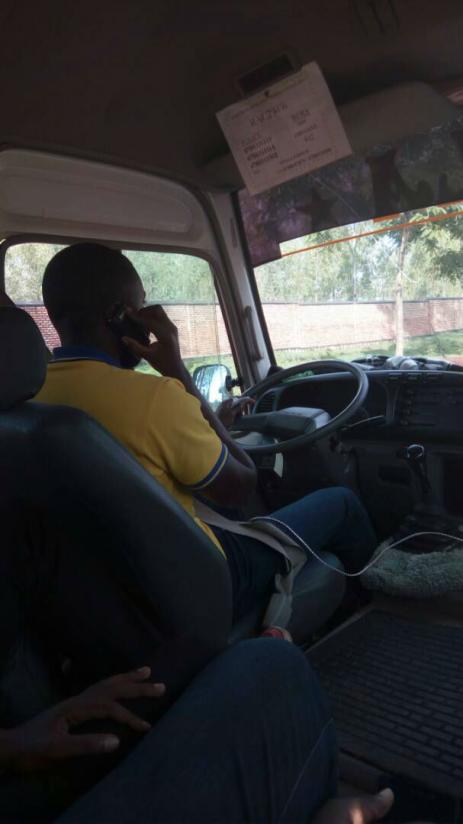 A photo of Emmanuel Ndereyimana talking on phone while driving, taken by one of the passengers. / Courtesy