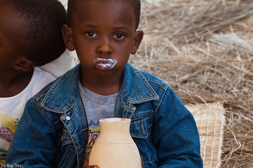 A kid takes milk during an event last year. / Nadege Imbabazi