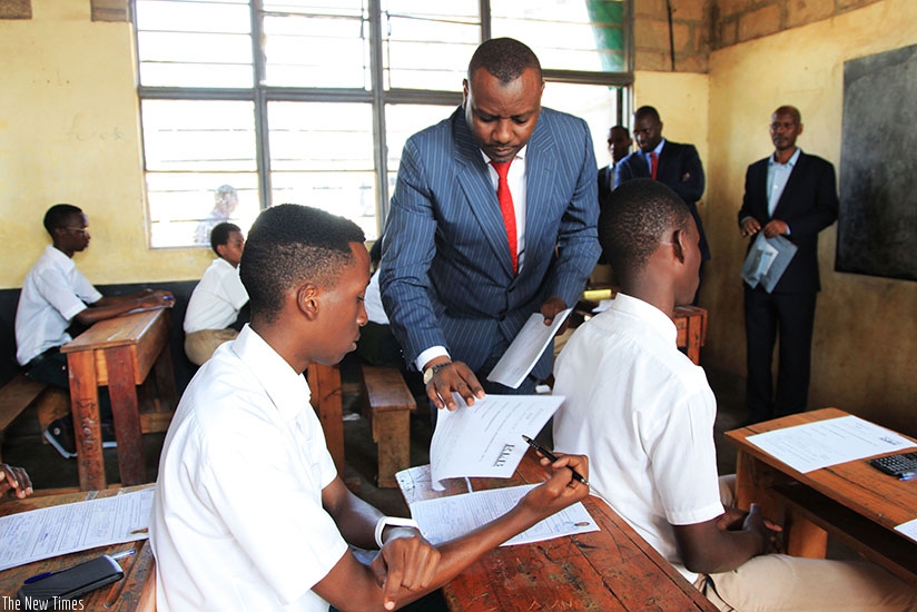 The State Minister for Primary and Secondary Education, Isaac Munyakazi, distributes examination scrips to the candidates at GS Remera as national O and A-Level examinations starte....