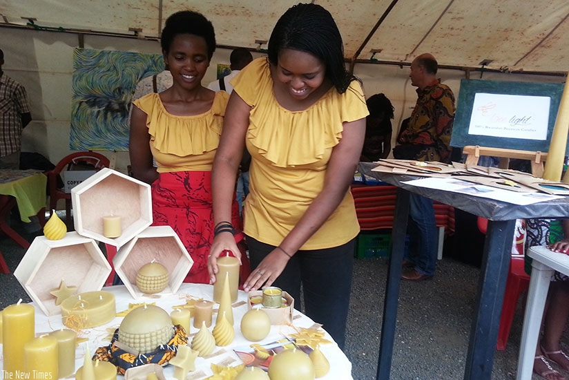 Bee Lights founder, Nathalie Neema (R), making candles from bee wax.