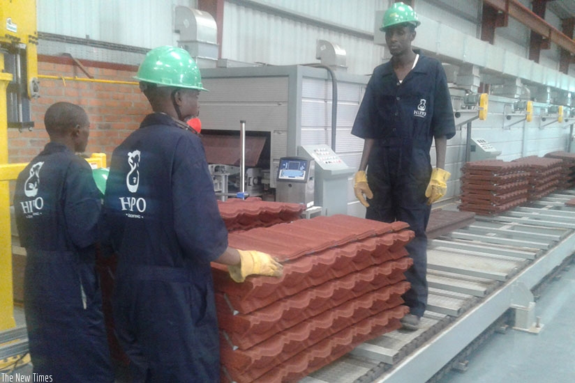 Workers of Hippo, the makers of stone coated steel roofing tiles based in Kigali Special Economic Zone. / File