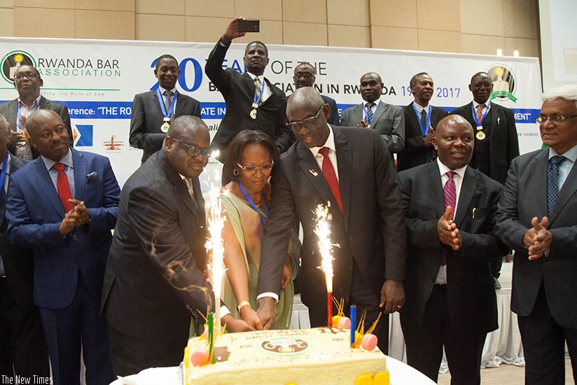 Justice minister Johnston Busingye (third right) and members of Rwanda Bar Association cut a cake during the Bar's 20th anniversary celebration in Kigali yesterday. Busingye commen....