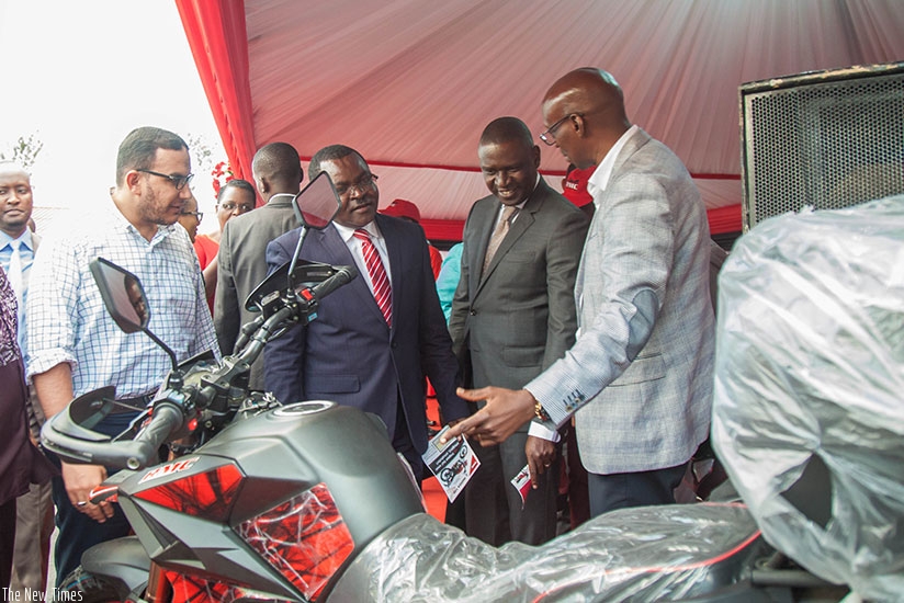 Trade and Industry minister Vincent Munyeshyaka (2ndL) and Private Sector Federation chairperson Benjamin Gasamagera (2nd R) visit Rwanda Motor Company stand during the exhibition ....