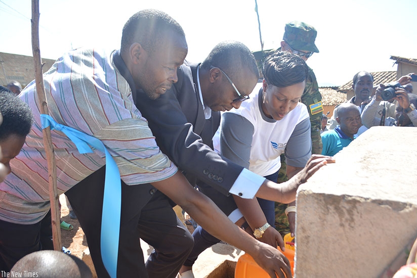 Umugwaneza (right) and Mbabazi (second left) launch the water taps as Rwoga village leaders watch on. The water point was constructed using funding from BDF. / Frederic Byumvuhore