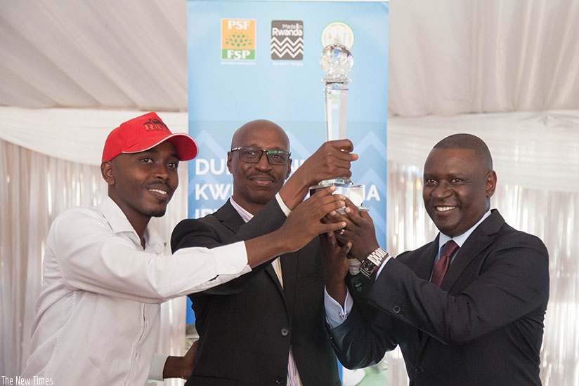 Rwanda Motorcycle Company representatives receive the Best Exhibitor's award from PSF's  Gasamagera (R) during the official closure of the Made-in-Rwanda Expo. Nadege Imbabazi. 
