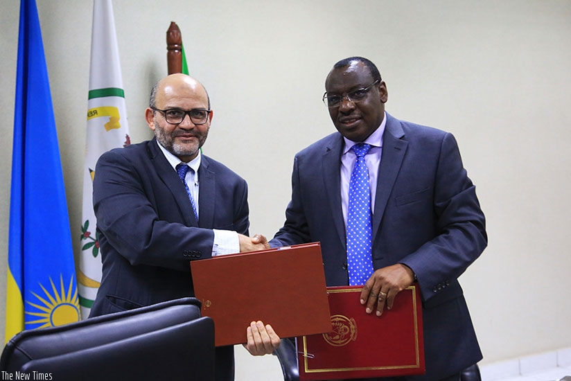 World Bank Country Manager Yasser El Gammal exchanges documents with Minister Gatete after signing the agreement in Kigali yesterday. Sam Ngendahimana.