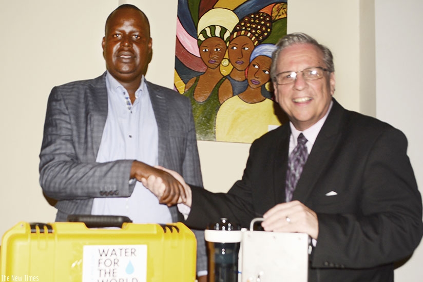 Thomas (right) hands over some of the equipment to Byiringiro in Kigali. / Frederic Byumvuhore.