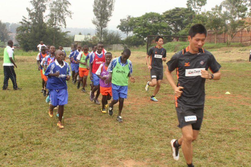 Japanese coaches Shuzo Sakamoto (in-front) and Daichi Motomatsu lead the children during the first training session.