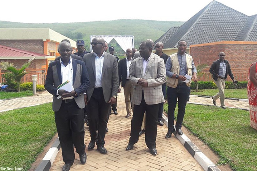Nsengiyumva (wearing checked coat) and COPRORIZ Ntende officials tour the group's hotel and multipurpose commercial building before the launch. / Kelly Rwamapera.