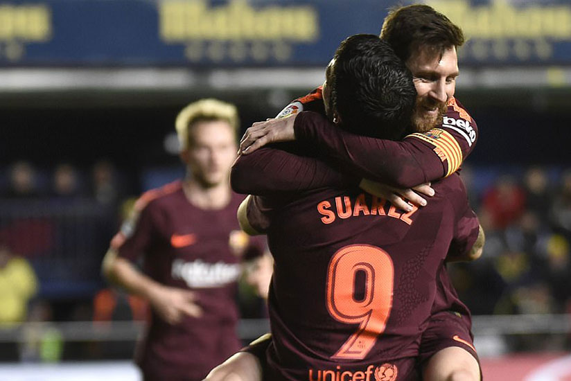Lionel Messi receives a bear hug from team-mate Luis Suarez after doubling Barcelona's advantage late on. / Internet photo