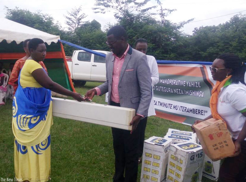 Bisiza handing over a knitting machine to one of the cooperatives. / Michel Nkurunziza