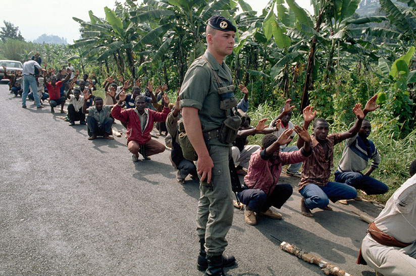 A French soldier walks past a group of Interahamwe militia in training ahead of the 1994 Genocide against the Tutsi. / Net photo