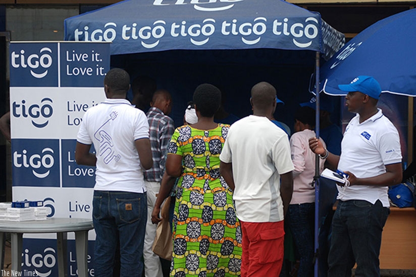 Tigo clients buy airtime at a Tigo stand