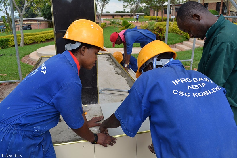 IPRC-East students lay tiles on the Genocide memorial at the school. / Kelly Rwamapera.