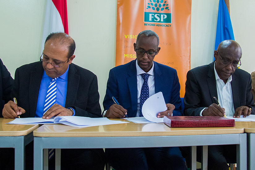Dr Mohamed Galal,(L)  sign documents with, PSF Chief Executive Officer, Stephen Ruzibiza (C) and Philibert Afrika board chairman of University of Kigali. / Timothy Kisambira