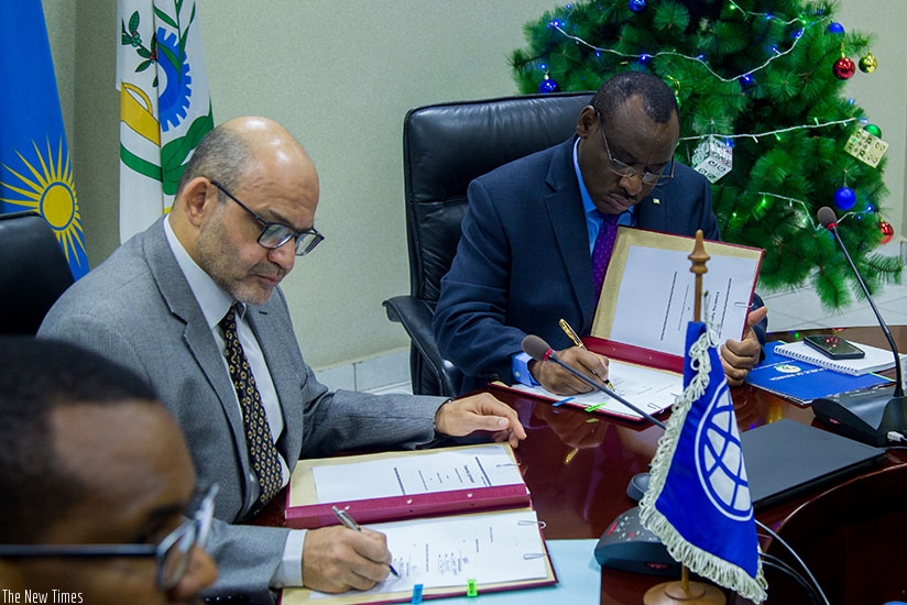 finance manager Claver Gatete,( R) together with Yasser El-Gammal, World Bank Country Manager sign a finance deal in Kigali. Timothy Kisambira 
