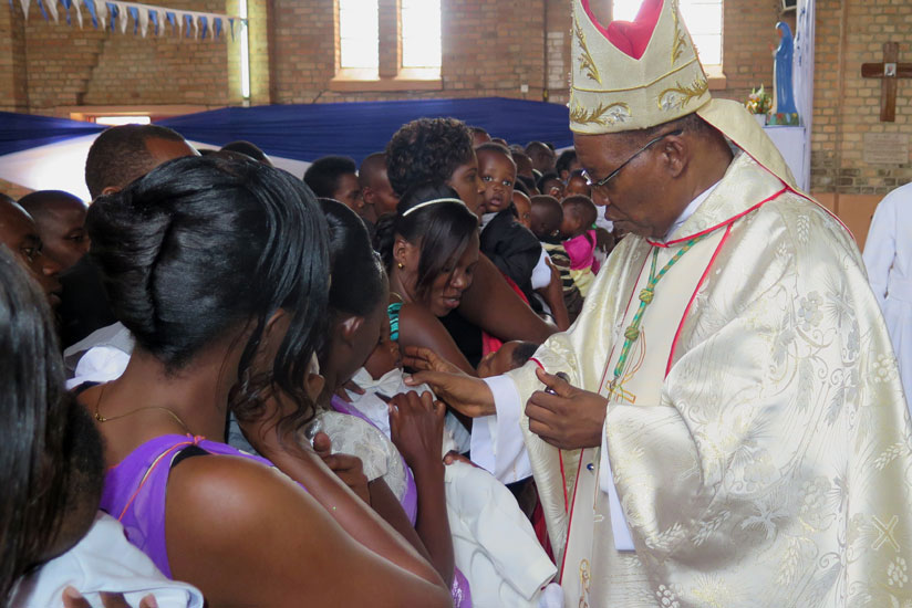 Monsignor Philippe Rukamba, the Bishop of Butare Diocese, giving benediction ointment to children in baptism, during a Christmas mass at Butare Cathedral in Huye last year. Rukamba....