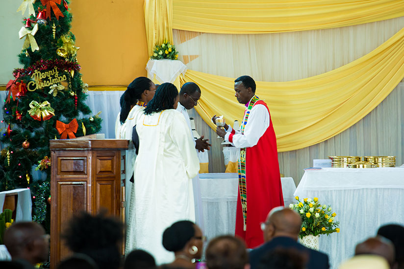 The Bishop of Kigali, Louis Muvunyi gives Holy Communion to Christians at St Etienne Cathedral in Kigali yesterday. He urged believers to reflect on their lives during the Christma....