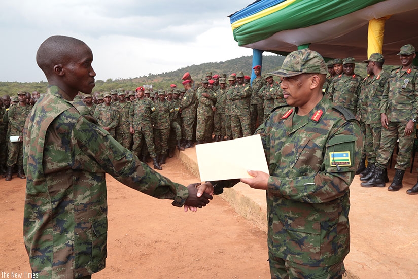 Gen Nyamvumba rewards Private Patrick Nkurunziza, who emerged the best from the 09/2017 intake, after the one-year military training. Courtesy.