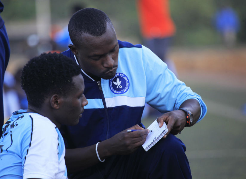 Police FC Head coach Innocent Seninga talks to his striker Abeddy Biramahire during the half time at Kicukiro stadium. / Sam Ngendahimana