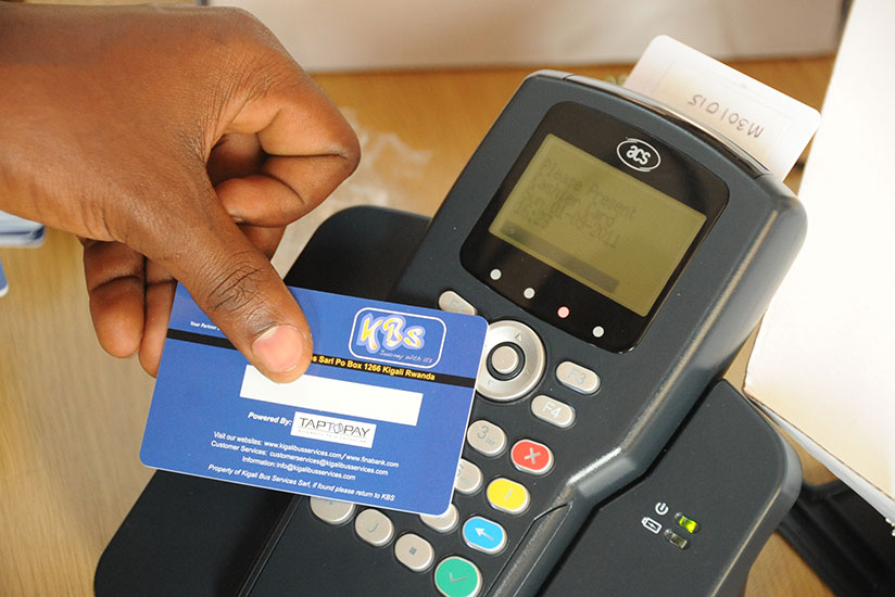 A passenger uses a Tap and Go card to pay his fare as he boards a bus. AC Group, the brains behind the cashless mode of public transport payment say this year, 97% of people in Kig....