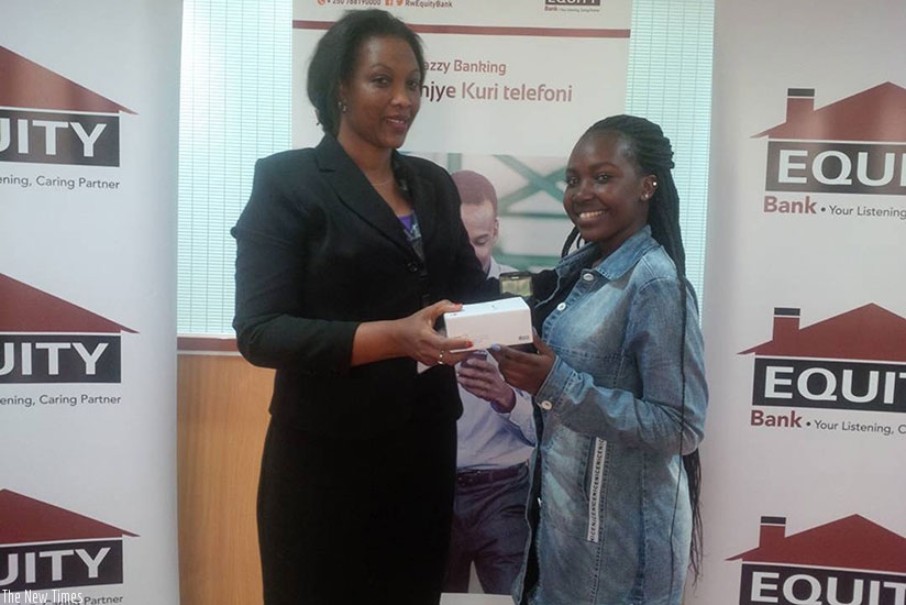 Murungi (right) receives her new Huawei smartphone from Niragira. (Joan Mbabazi)