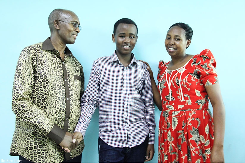 PLE star Sam Musoni Nshuti's parents, Edson Musoni and Aloysie Mutoni, pose for a photo with their son at The New Times Publications headquarters in Kigali yesterday. (Sam Ngendahimana)