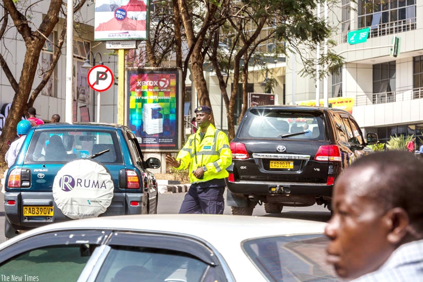 A traffic police officer guides motorists in Kigali's Central Business District. Motorists have decried the recent increase of insurance premiums by 73 per cent. File.