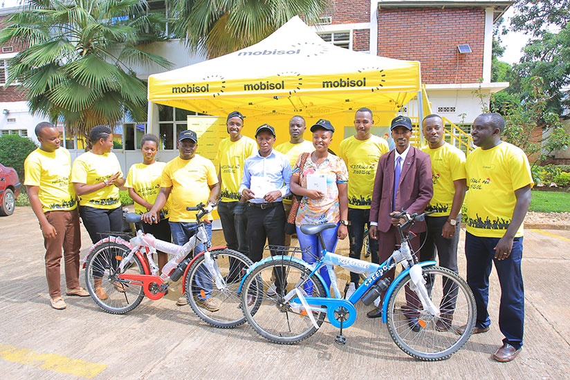 Mobisol officials pose for a picture with some of the first monthly draw winners. / Courtesy.