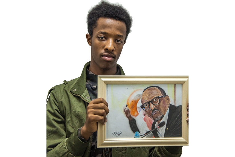 Peter displays a portrait of President Paul Kagame. 