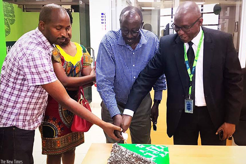 Odhiambo (right) is joined by KCB MTN Centre branch staff to cut a cake as he launches activities to celebrate the lender's 10 years in Rwanda. / Peterson Tumwebaze