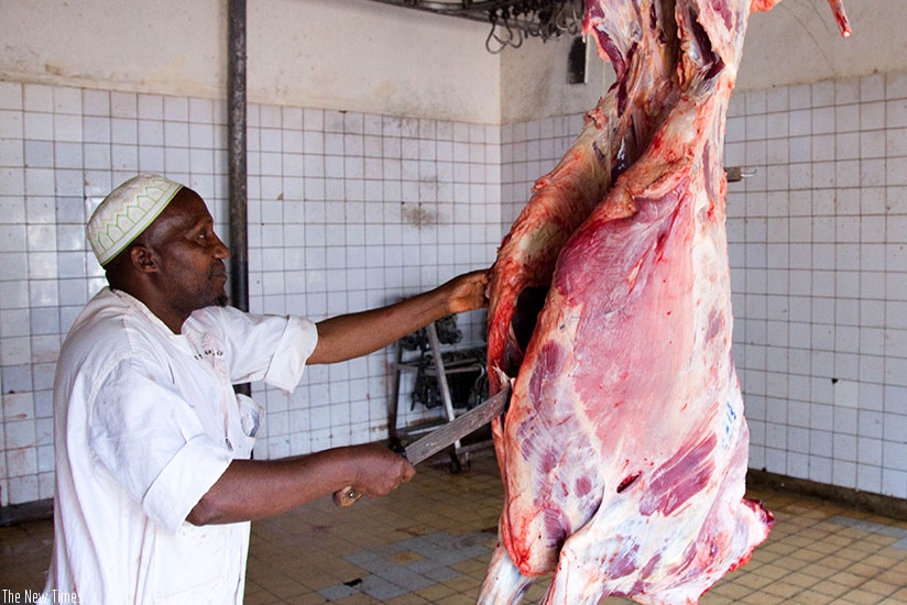 A butcher cuts meat at Nyabugogo abattoir. Timothy Kisambira.
