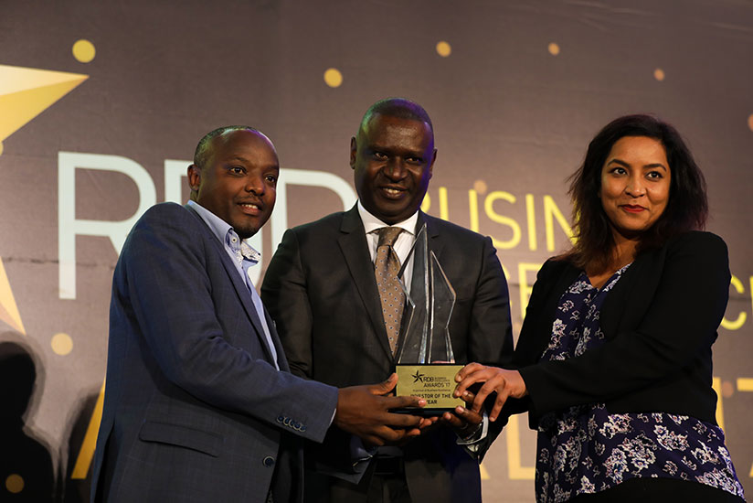 PSF chairman Benjamin Gasamagera (C) hands over the Investor of the year award to Prosper Ndayiragije, Country manager of Improved foods - Rwanda Ltd (L) and Darshana Josh, company....